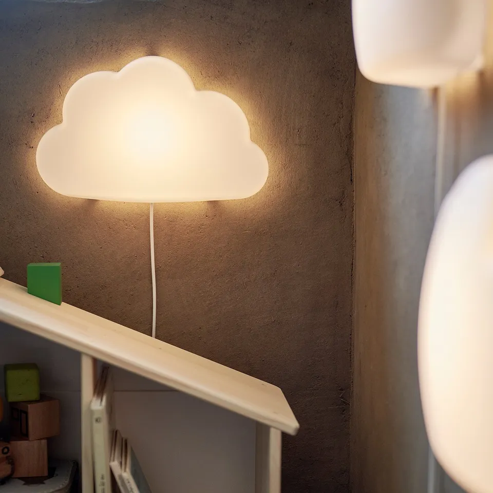 Cloud-shaped wall lamp, white, plastic, soft light, mounted above shelf.