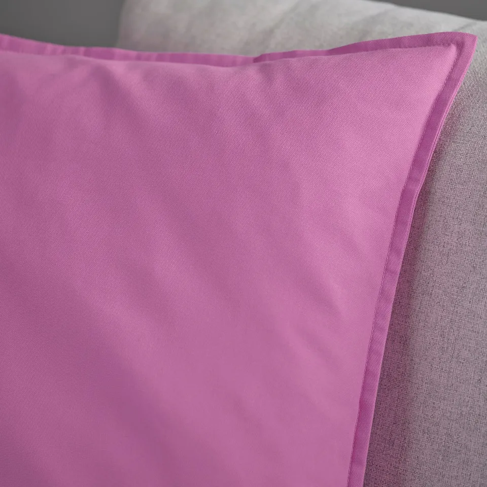 Close-up of smooth, vibrant pink cushion cover with neat stitching, showcasing its soft, high-quality fabric.