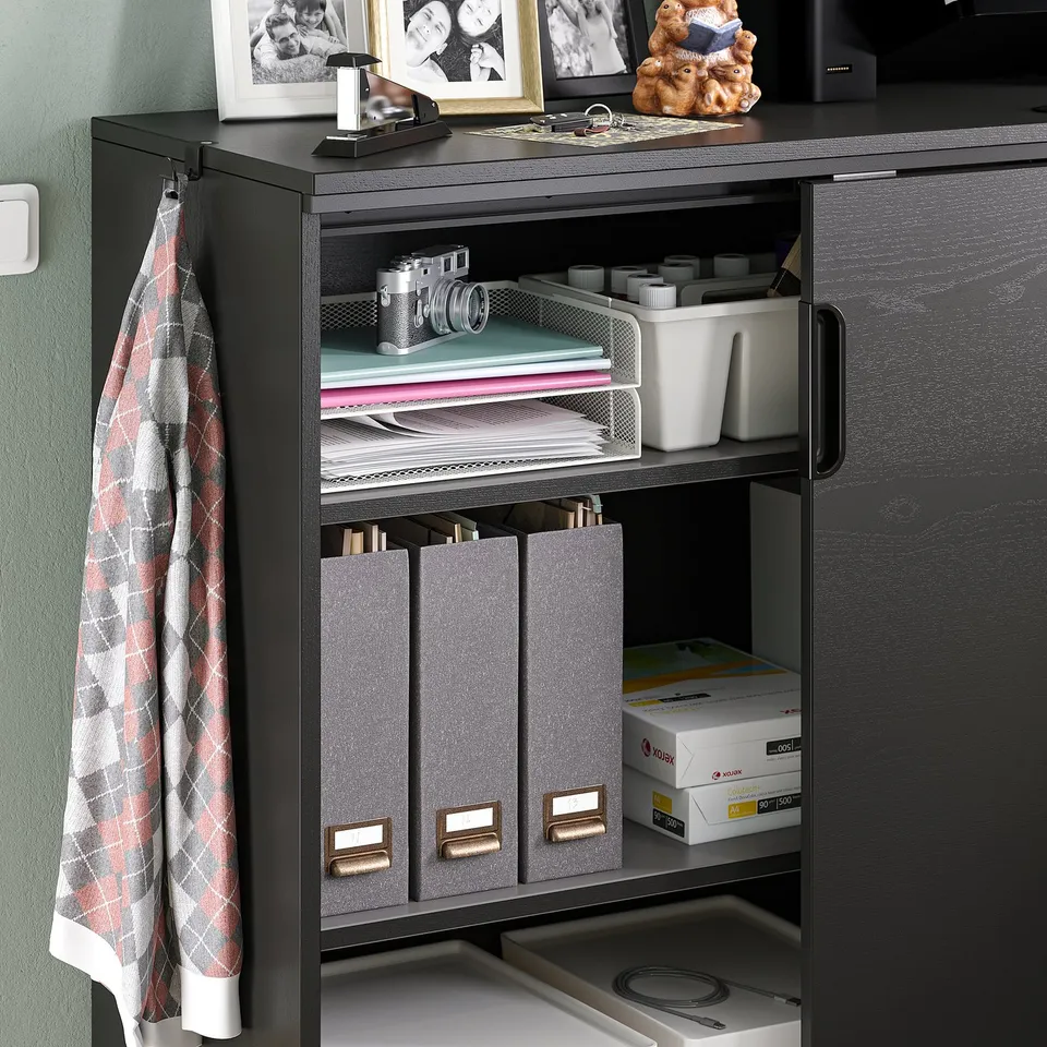 Black GALANT storage cabinet with adjustable shelves, holding documents, office supplies, and accessories.