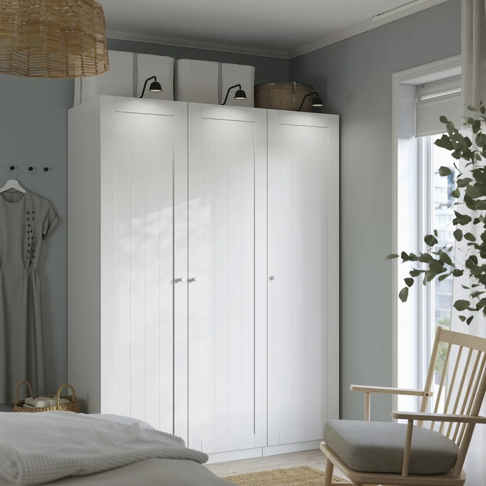 Modern bedroom with ikea PAX wardrobe, bed, chair, and decor.