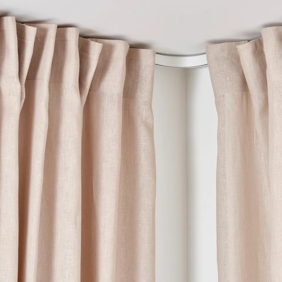 Beige curtains hung on a VIDGA track, blocking light. Ceiling-mounted, allowing for light blockage on sides.