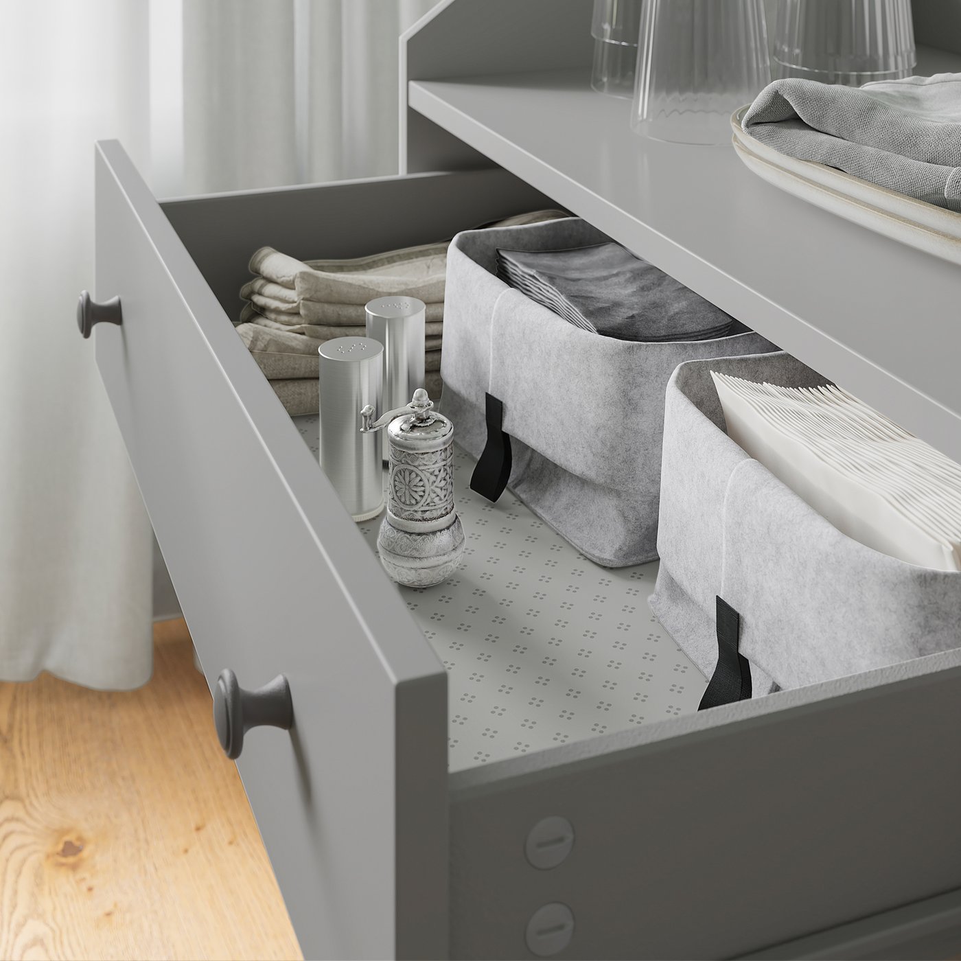 Open grey HAUGA drawer with fabric bins and folded towels, neatly organised.