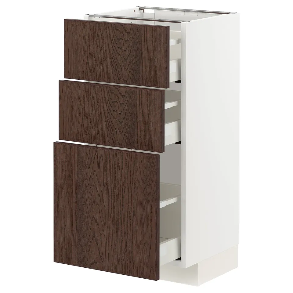 A white METOD kitchen cabinet with three dark brown sinarp drawers featuring oak veneer and solid wood edges.