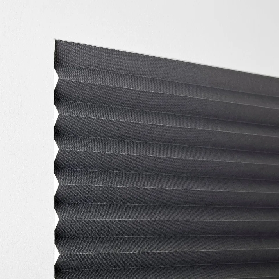A window blind partially closed, blocking light. It fastens with hooks and clips, suitable for smooth surfaces.