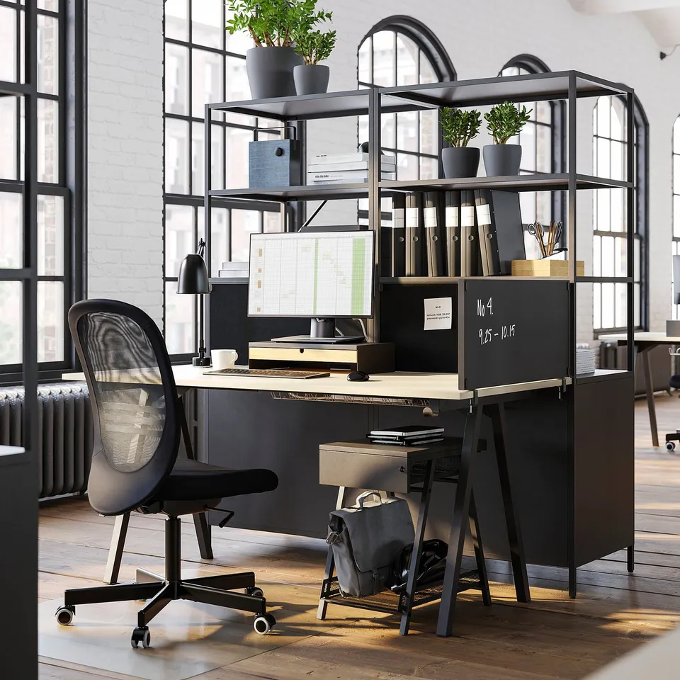 Modern black office desk setup with chair, computer, shelves, and plants; sleek, organised, and industrial design.