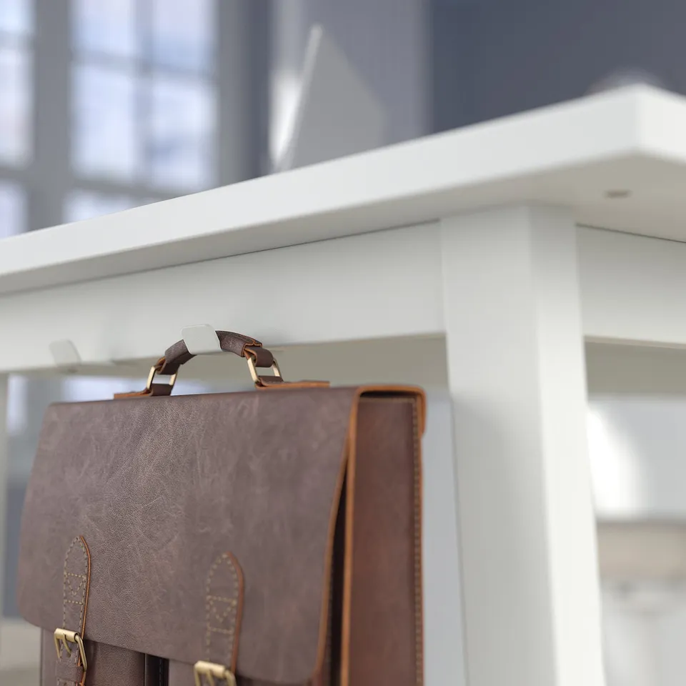Leather bag stops beneath high tables white surface. Ideal for meeting areas.