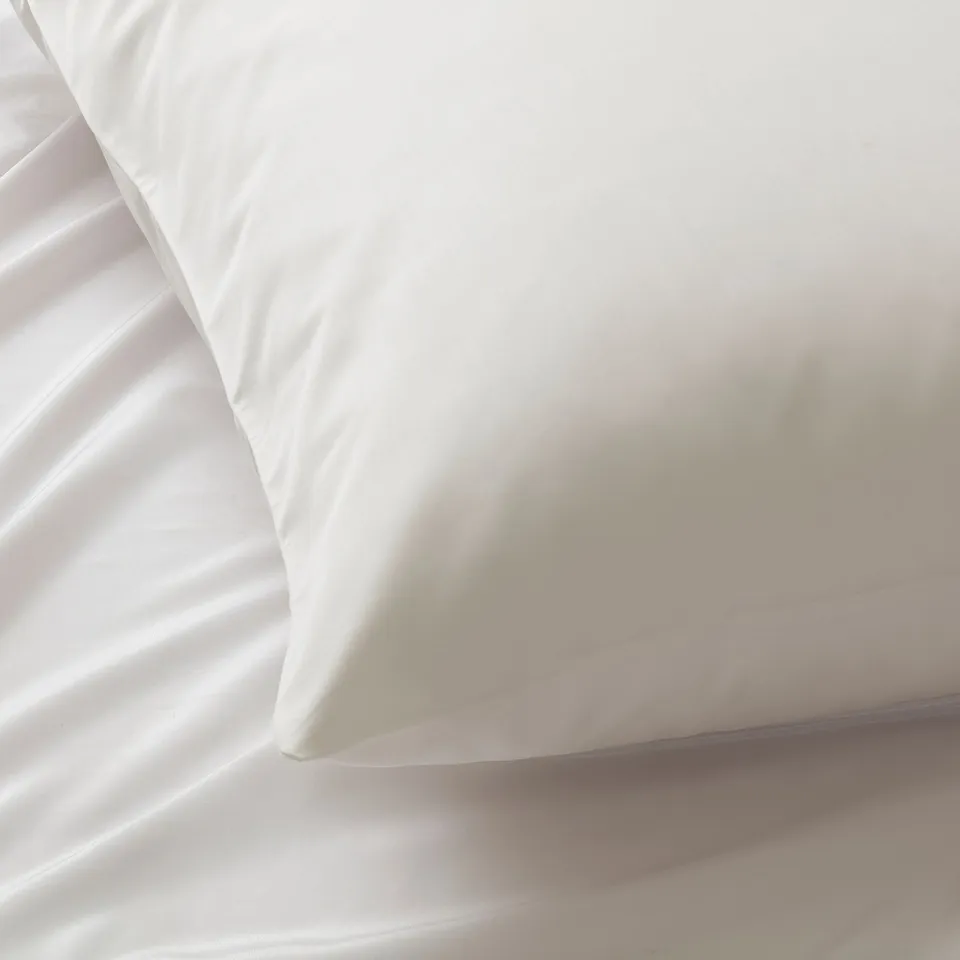 Smooth white cotton bedding with fine weave.
