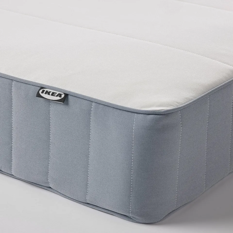 Close-up of an IKEA mattress, showing quality fabrics and construction. Visible logo, zip detail, and clean stitching.