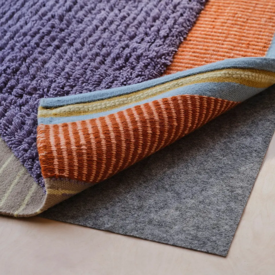 Four colourful rugs with purple, orange, and blue hues laid on light wooden floor.