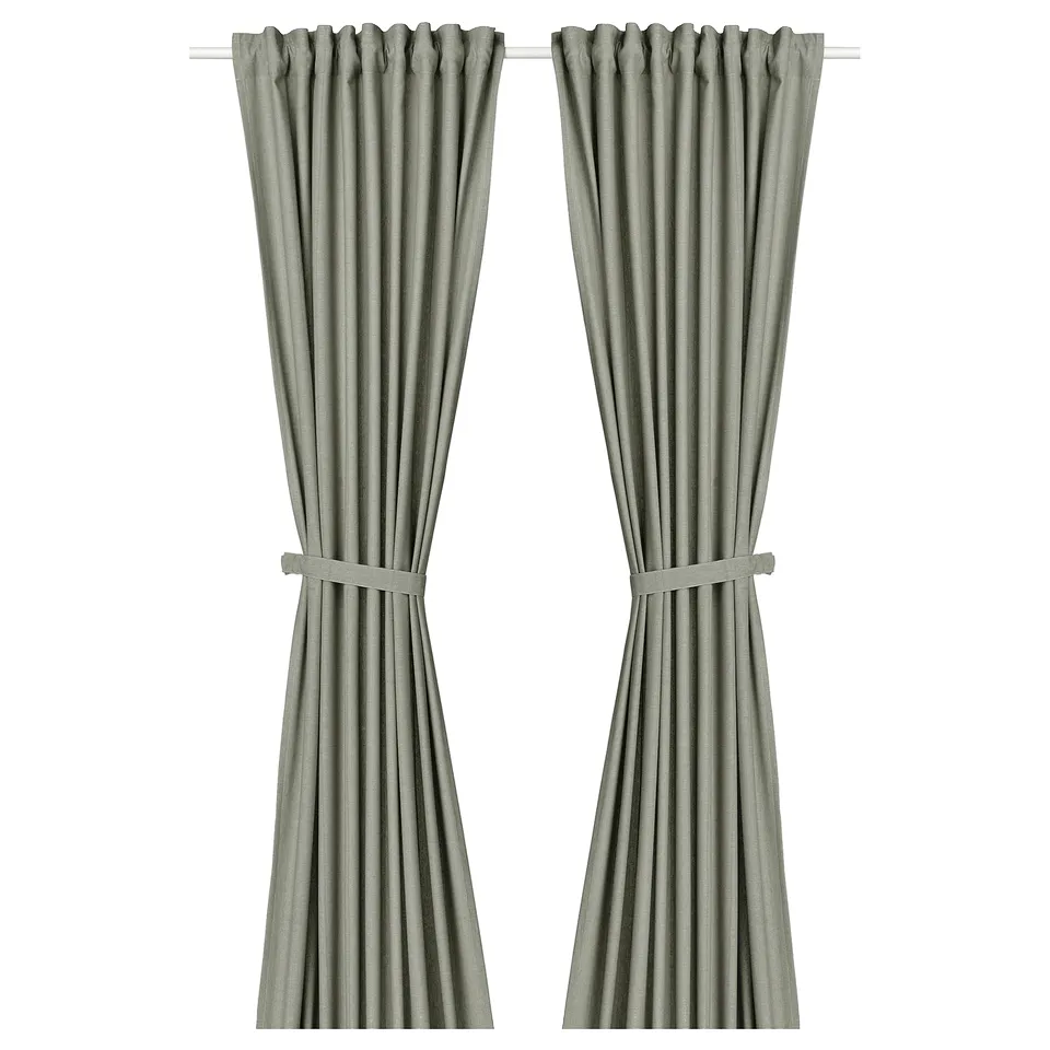 LENDA curtains in light grey green. Made from 100% cotton, they have a linear weave. Tied back, they frame a window, adding a decorative touch.