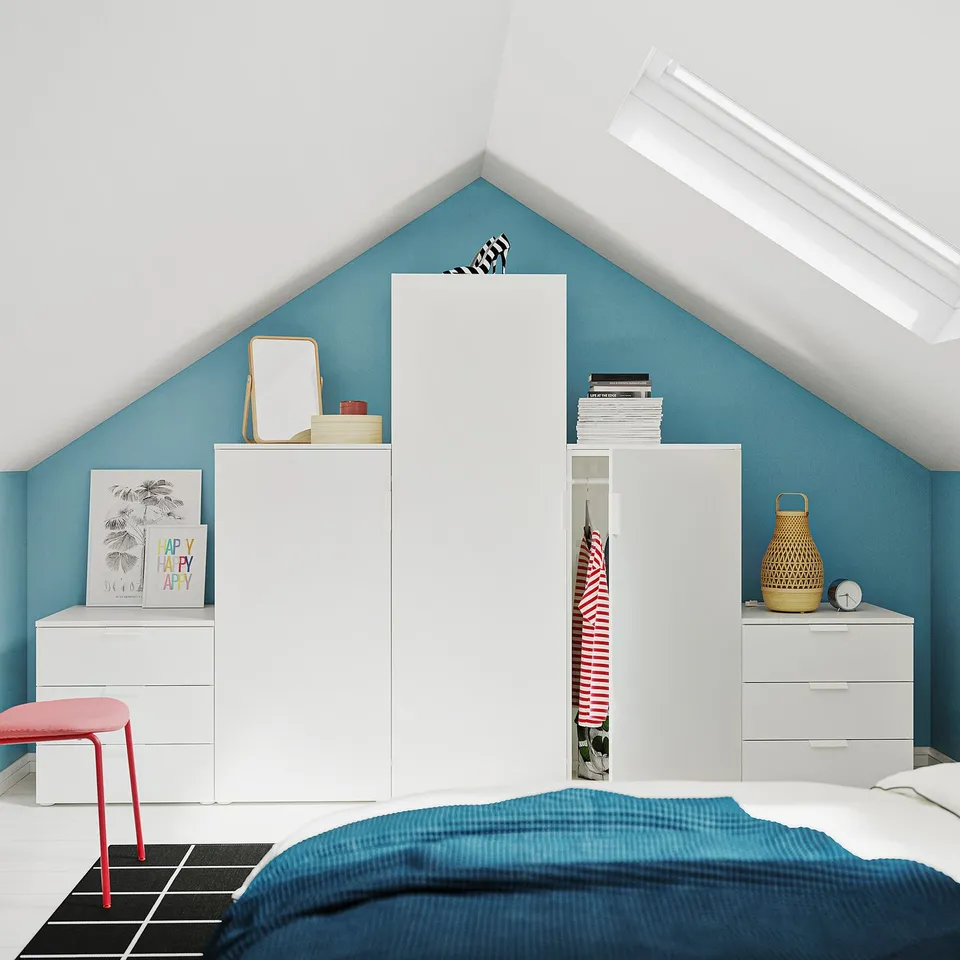 Bedroom with blue walls, white storage units, red chair, blue bedspread, and a skylight.