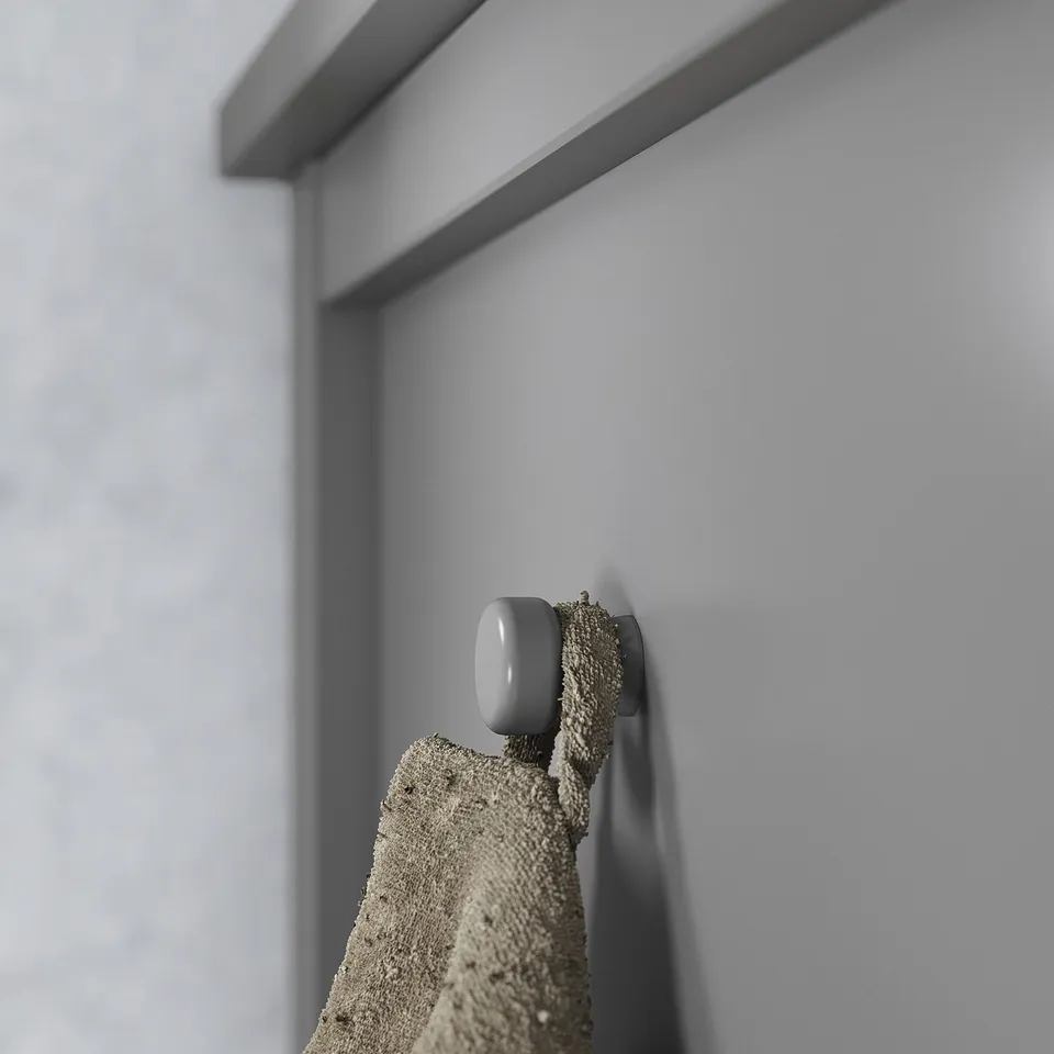 Grey hook on light wall, holding textured cloth. Simple, modern design.