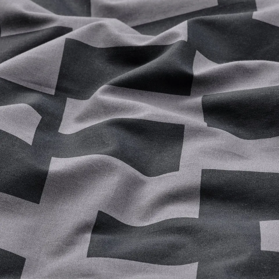 Abstract black-and-white geometric fabric design; smooth texture, intricate patterns.