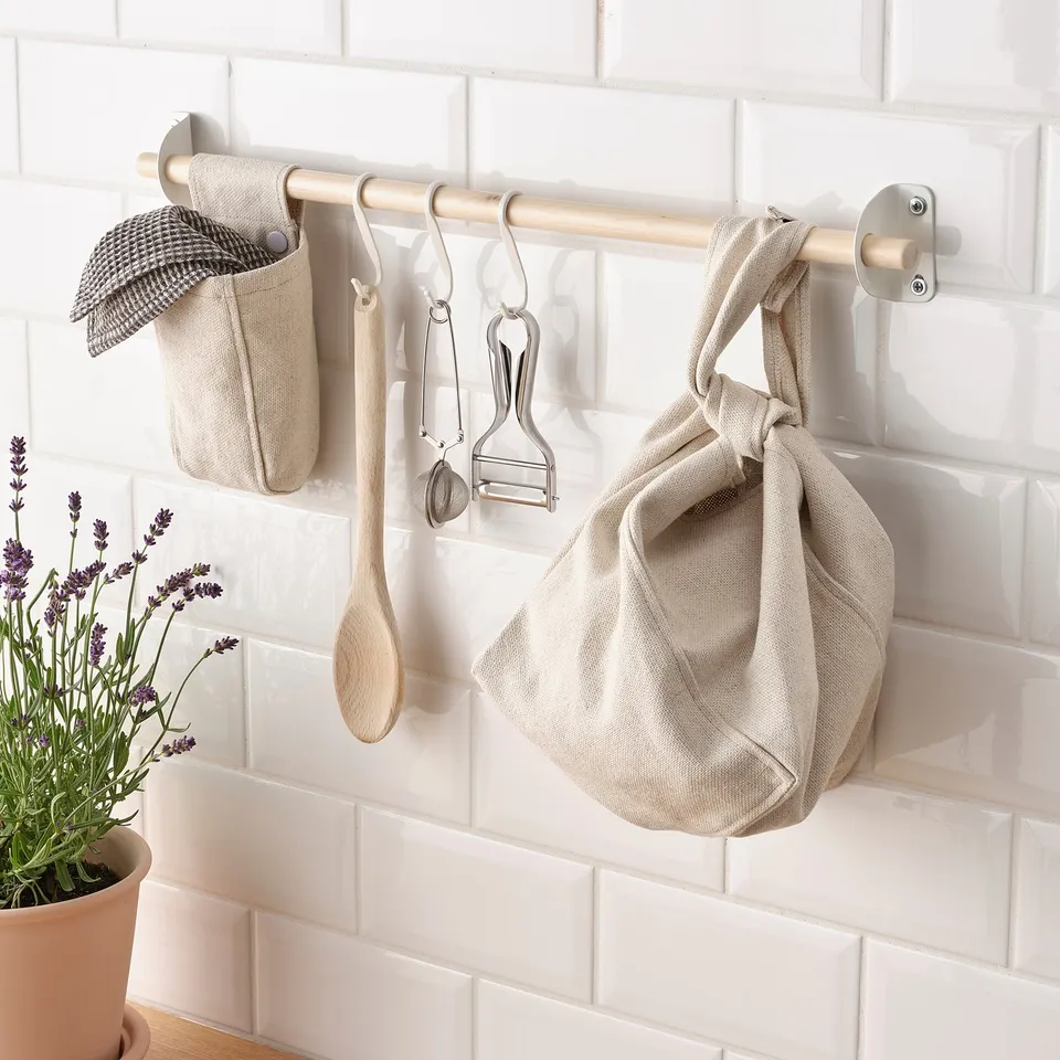 Kitchen organiser with hanging cloth bags and tools on rail, saving counter space.