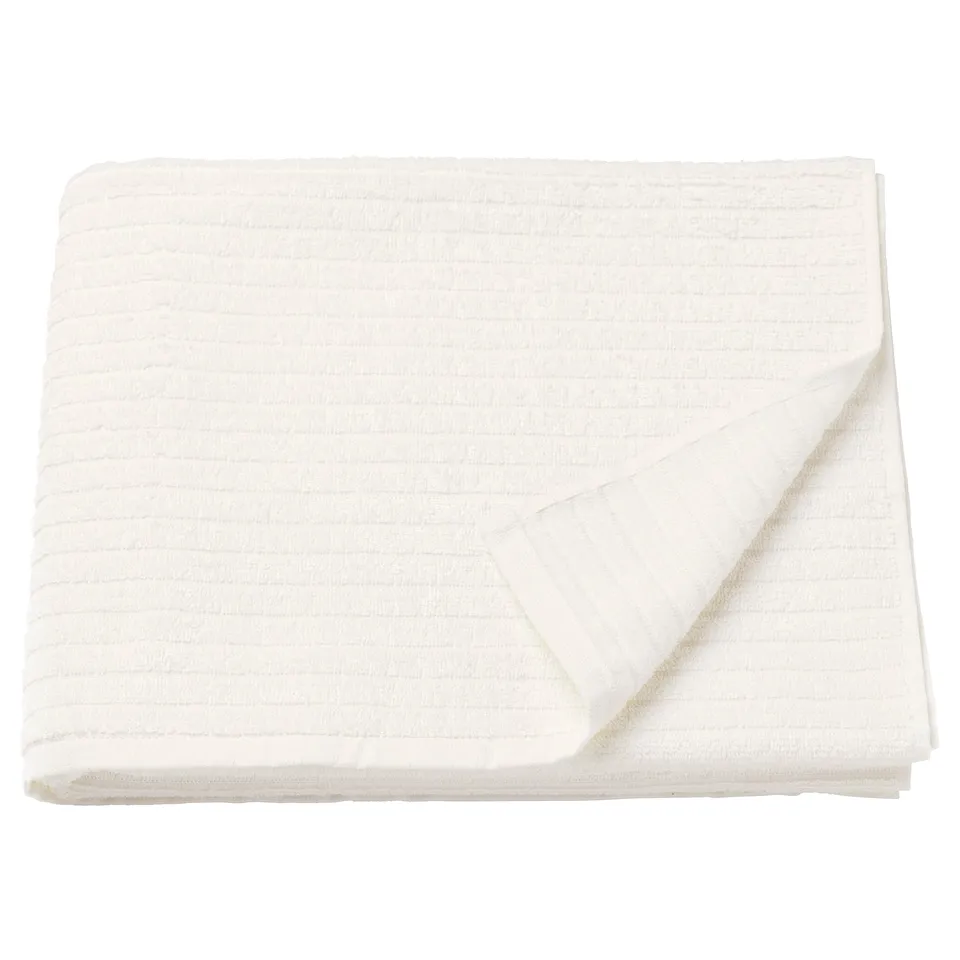 A VÅGSJÖN white cotton towel, neatly folded. Its soft, absorbent, and has a textured design.