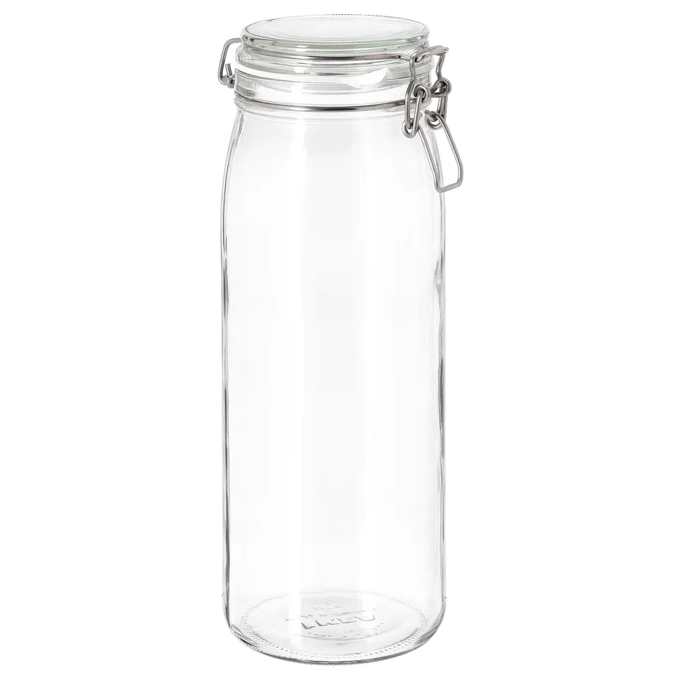 A clear cylindrical glass jar named KORKEN, with an airtight lid featuring a metal clasp. Perfect for storing food or serving.