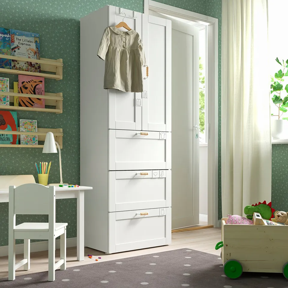 Kids room with white SMÅSTAD wardrobe, green rug, and wooden toys.