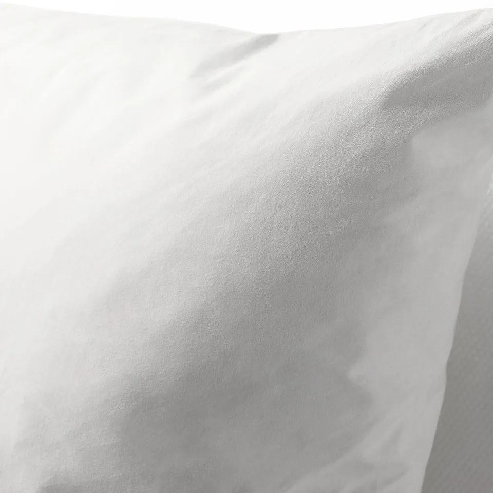 Close-up of a soft, pure cotton cushion filled with duck feathers, giving a luxurious and supportive feel.