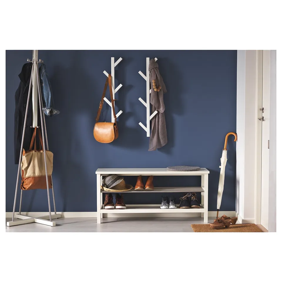 Blue wall with TJUSIG storage: coat rack, shoe bench, umbrella, doormat.