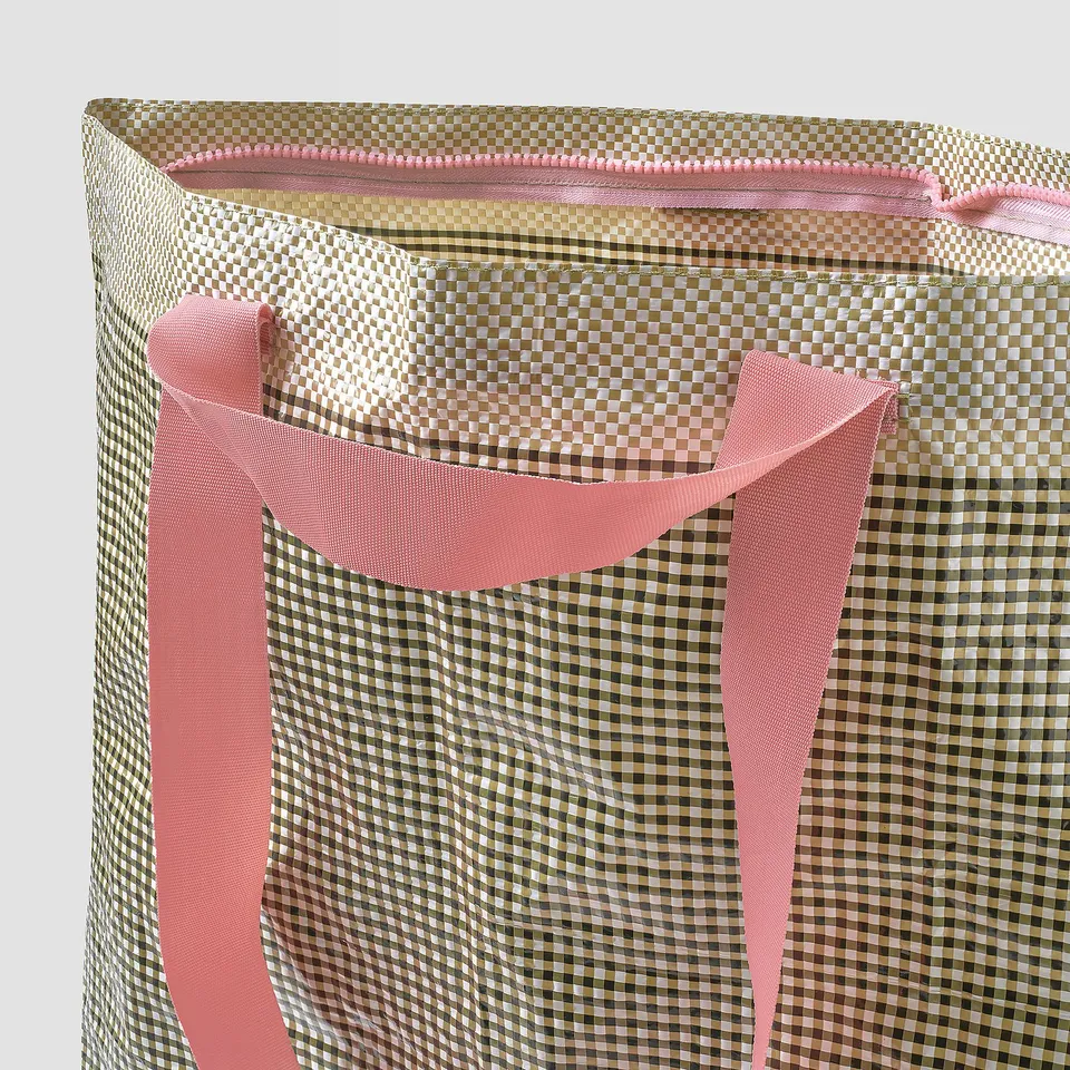 Foldable shopping bag with chequered pattern and pink handles. Sturdy, eco-friendly polypropylene material.