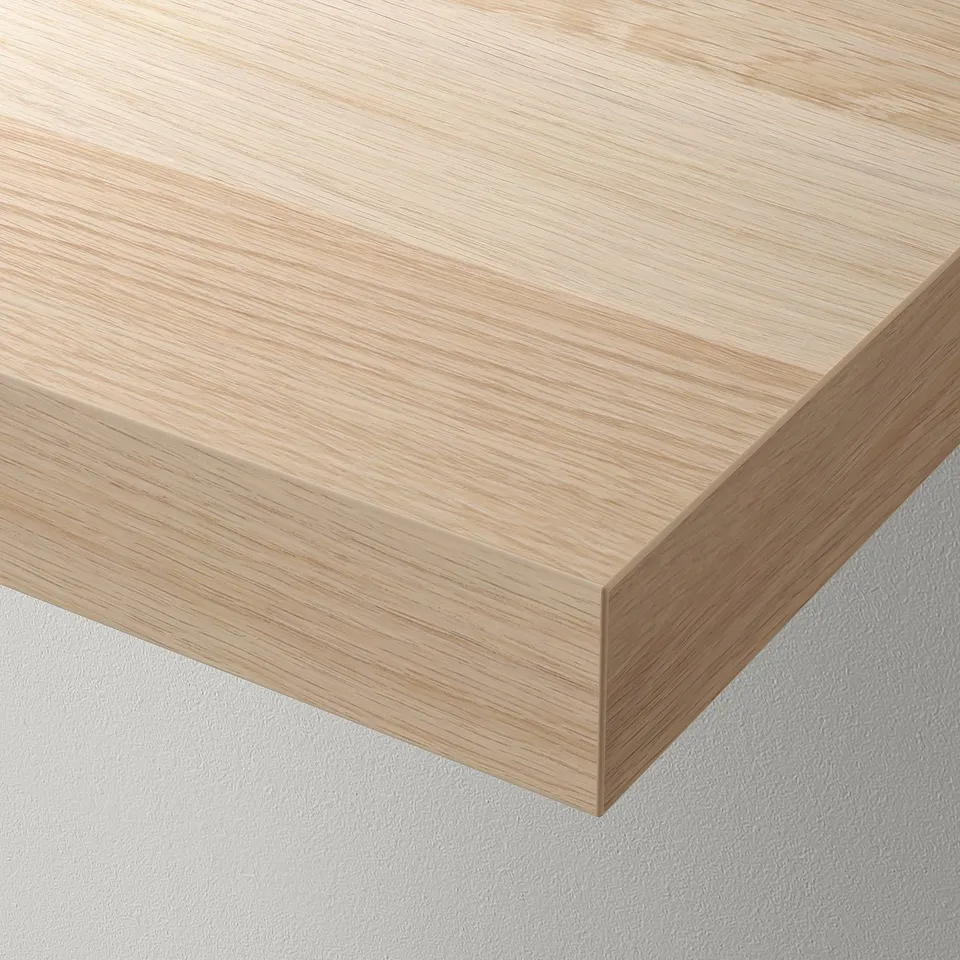 A floating wooden shelf mounted flush against a wall, showcasing clean, modern design.