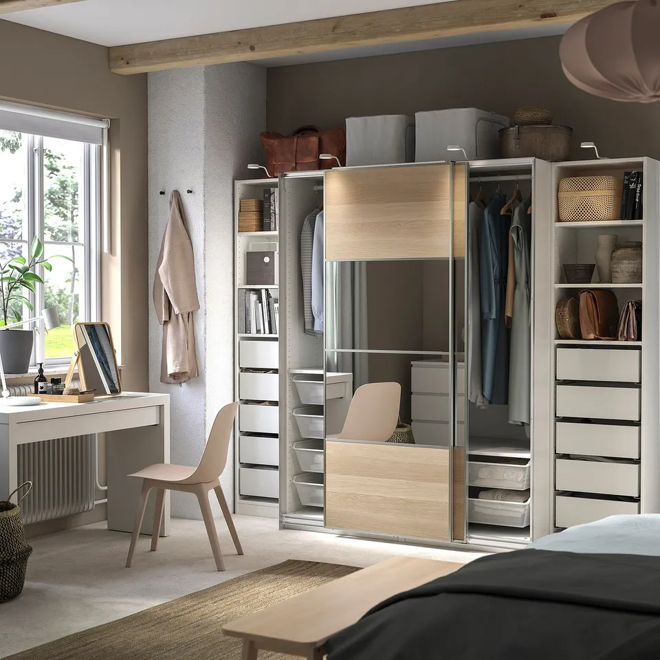Organised bedroom PAX wardrobe in white and light wood, sliding doors, clothes, shelves, and drawers.