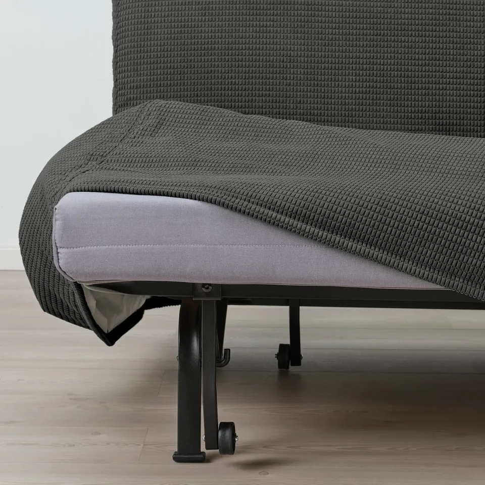 A grey sofa-bed with a visible, adjustable mechanism and wheels, designed to convert into a bed.