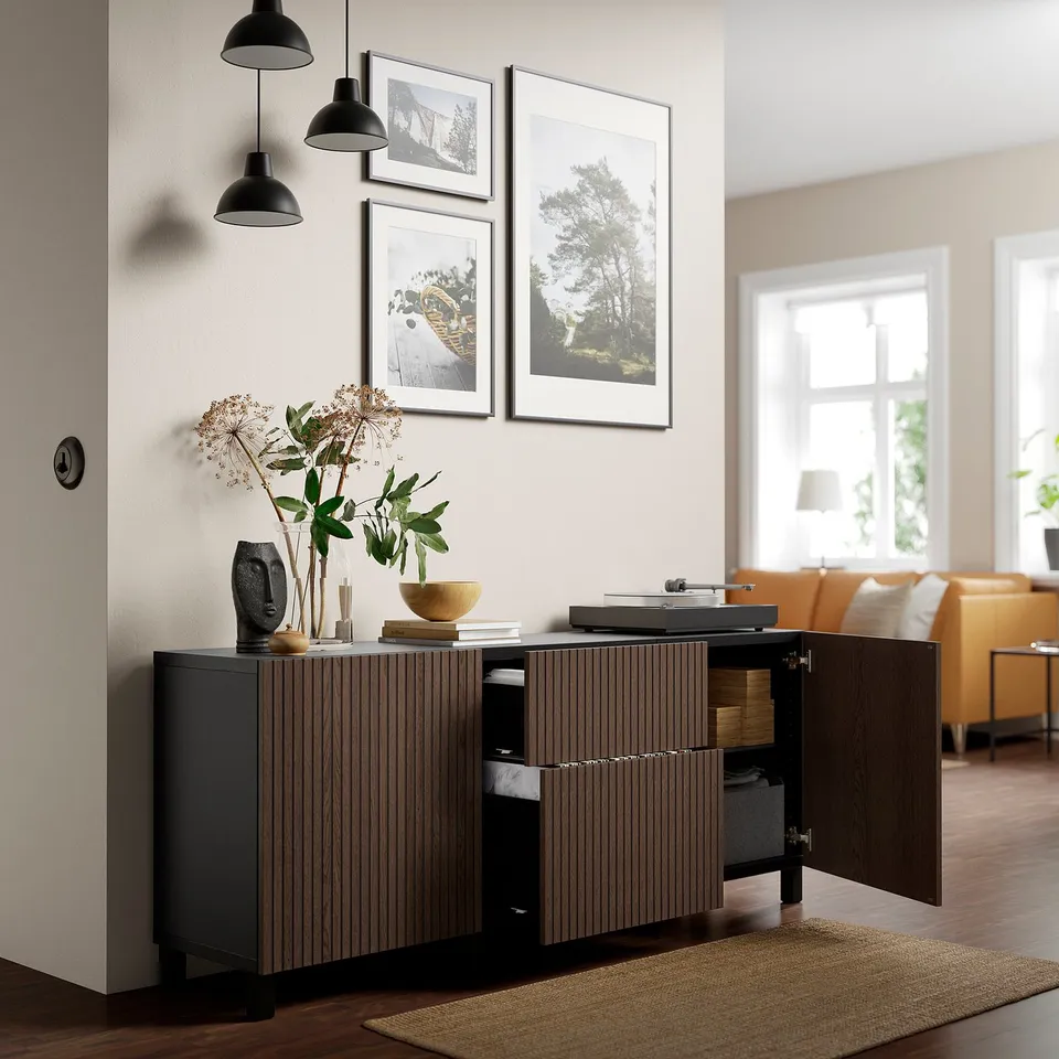 Modern cabinet with wooden grain, open doors revealing storage compartments. Displayed in a stylish living room with records and decor on top.