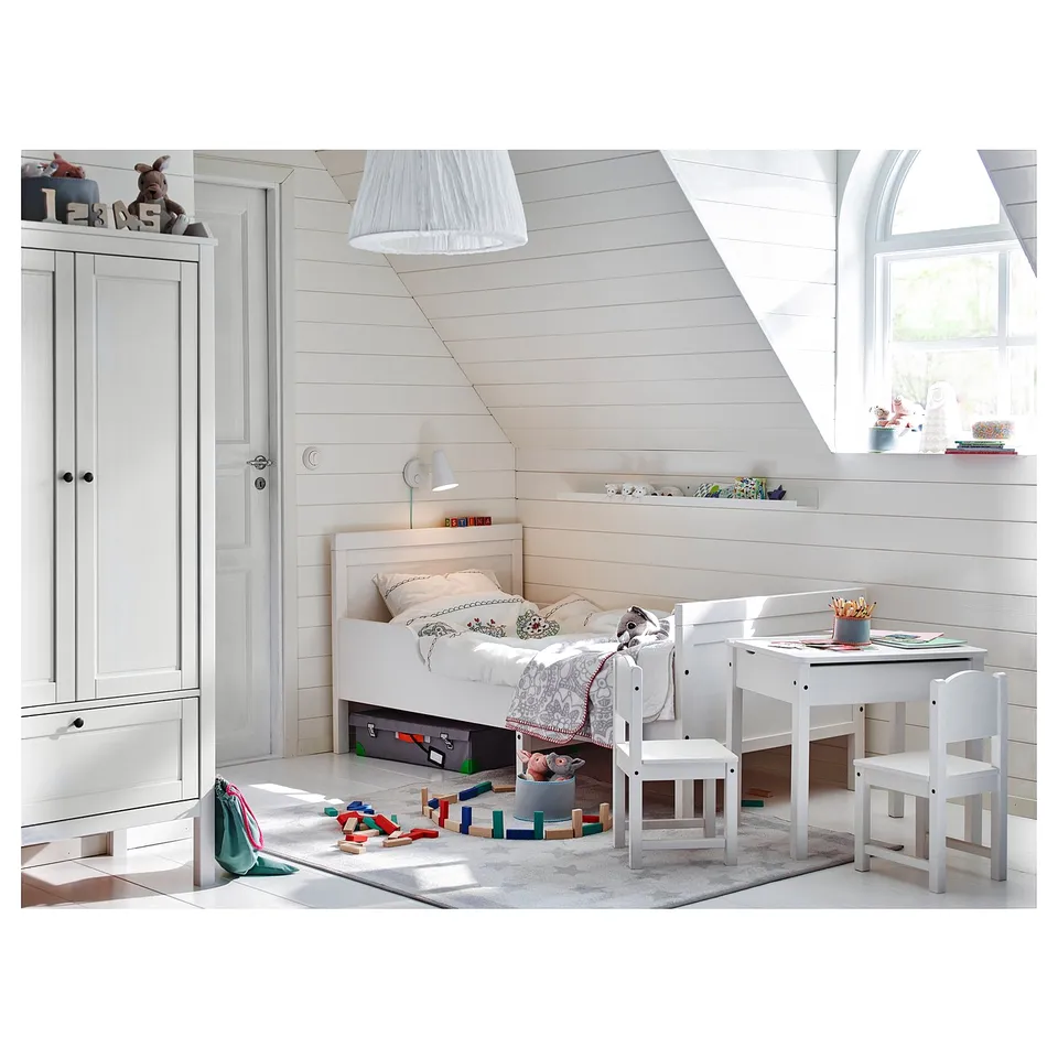 A bright, white kids room with a small bed, study table, and chair made from SUNDVIK series in pine wood, ideal for play and study.