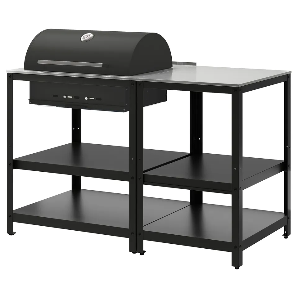 An all-black GRILLSKÄR charcoal grill on a metal stand with three shelves. The stand and grill are modern and sleek, designed for outdoor use.