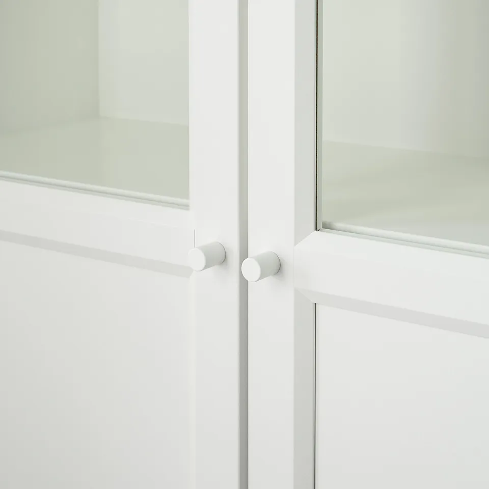 White cabinet with frosted glass doors and circular metal hinges, well-crafted.