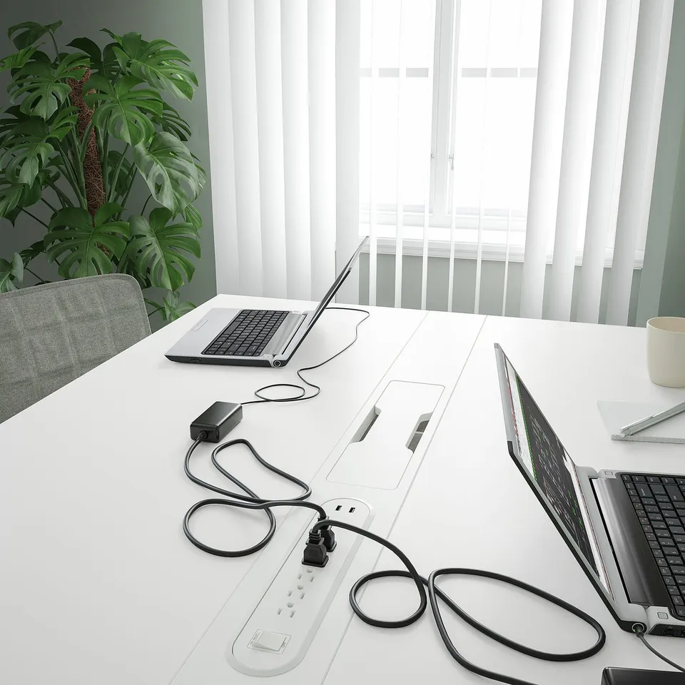 Modern conference table with integrated power strips and cable management, suitable for business meetings.