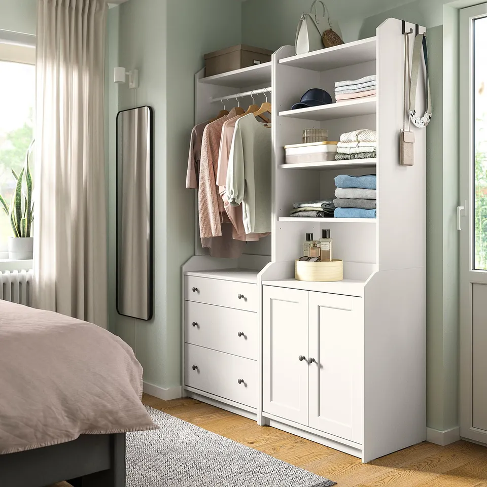 Bedroom with white HAUGA storage combo: drawers, shelves, hangers. Light, airy, organised.