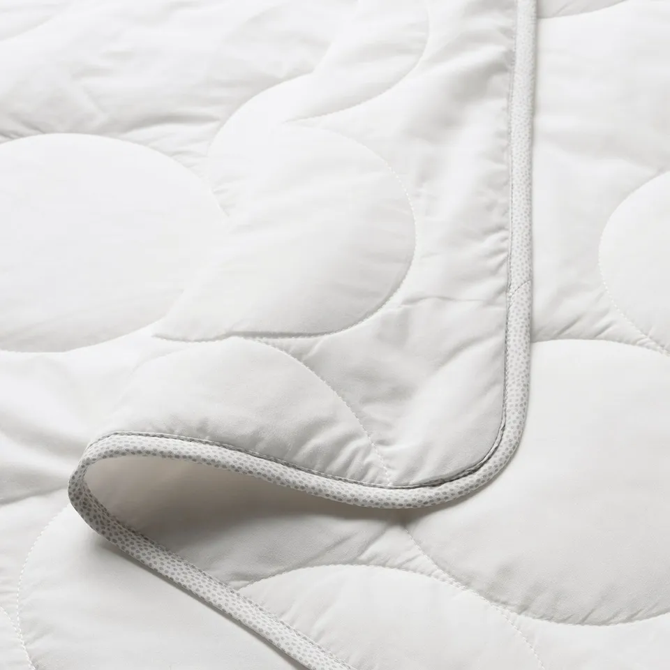 A close-up of a soft, quality baby duvet with smooth fabric & neat stitching.