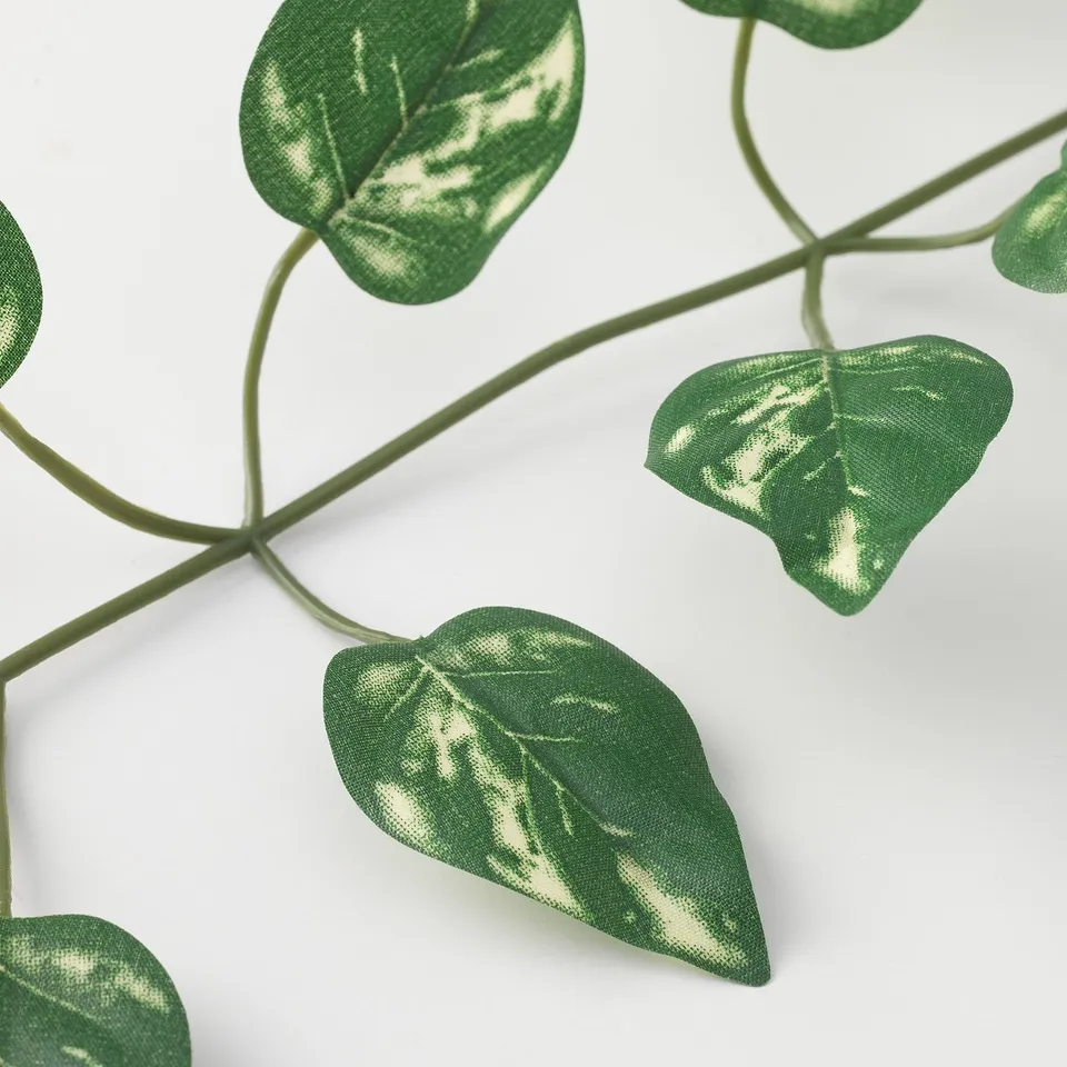 Realistic artificial green leafy vine, perfect for indoor or outdoor decor, made from recycled materials.
