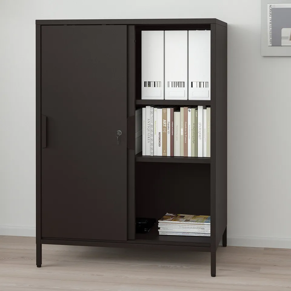 Black double-sided cabinet with sliding doors, lockable, used as room divider, adjustable shelves.