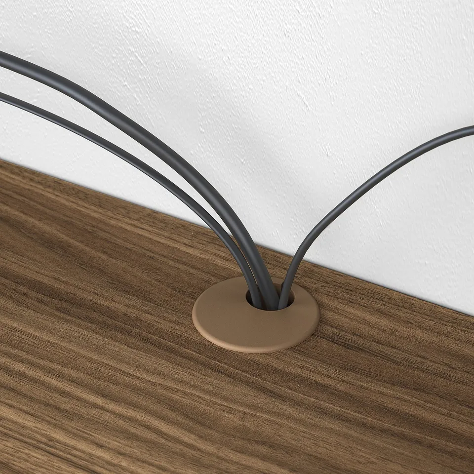 Wooden desk with cable management hole, two black cables neatly organised.
