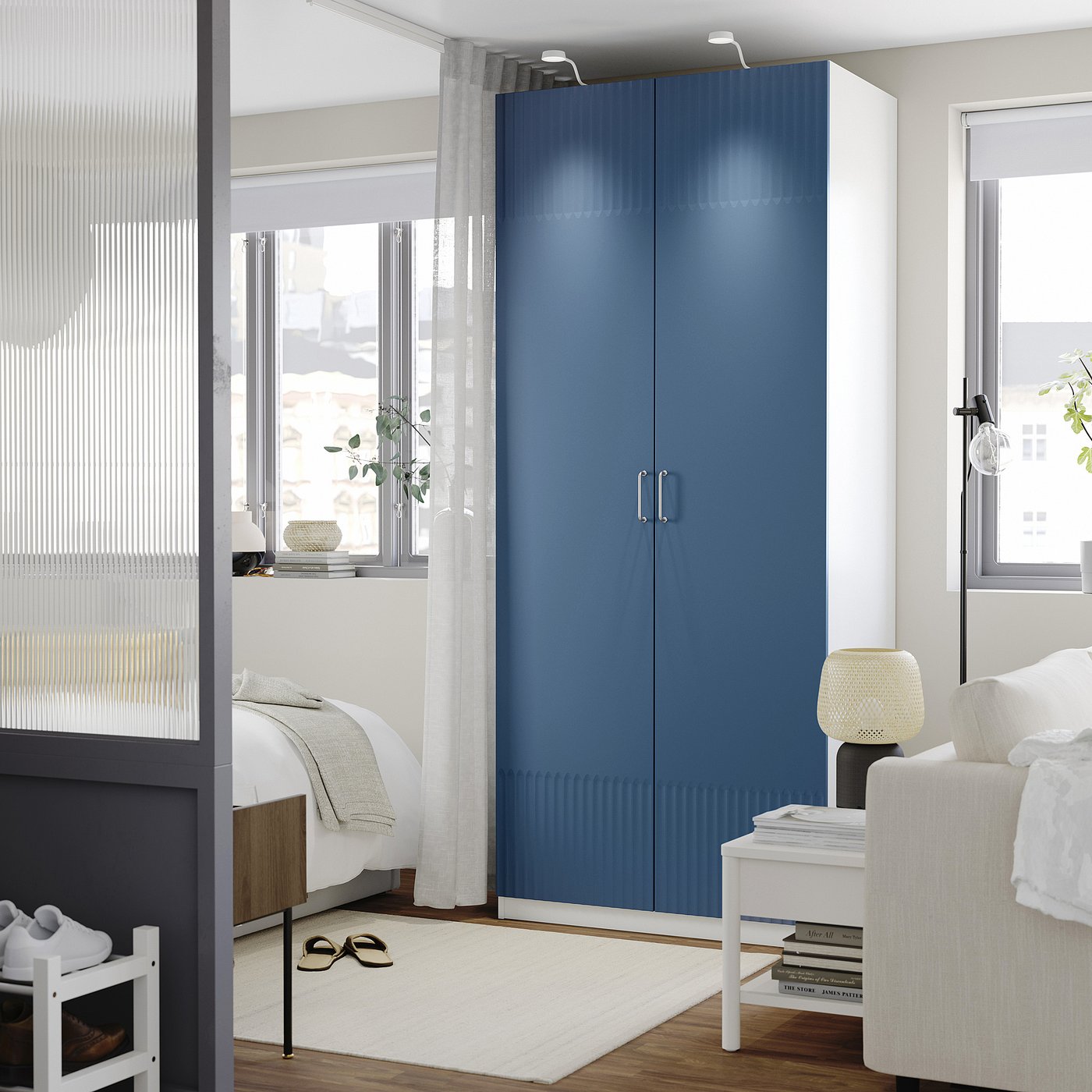 Modern bedroom with tall blue PAX wardrobe, soft-close doors, and cosy decor.