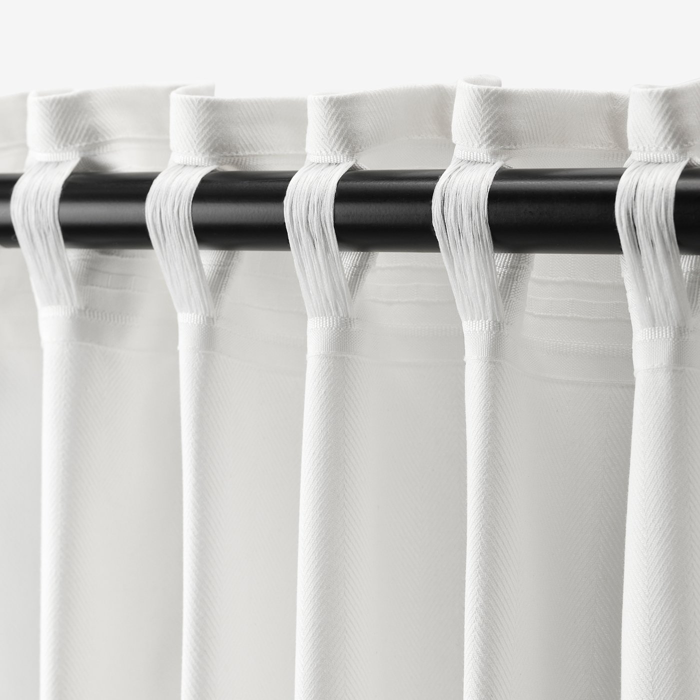 White curtains, drawn back with loops on black rod. Privacy and partial light philtre, adjustable pleats.