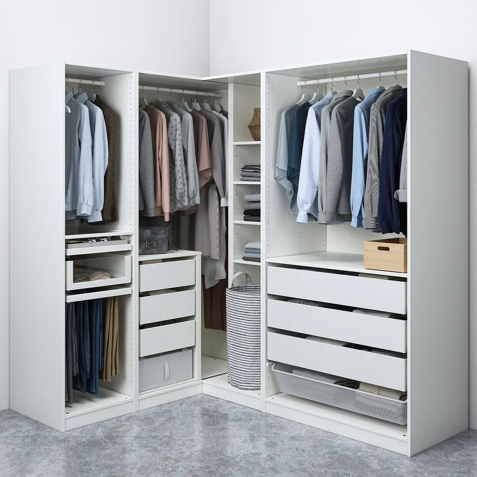A white corner closet storing clothes, with shelves and drawers organising garments neatly.