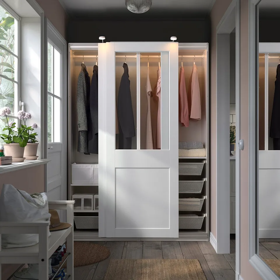 Large white sliding closet displays clothes neatly. Sized similarly to door frames, fits rooms aesthetic.