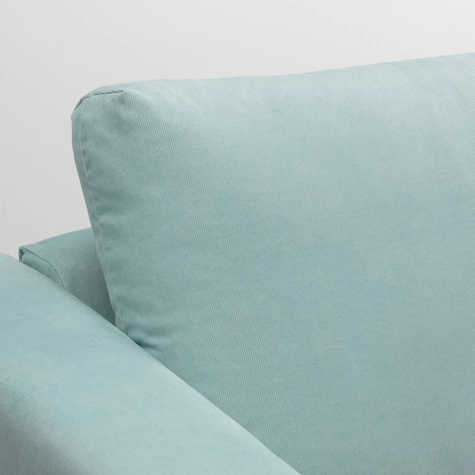 Plush, light blue sofa with rounded cushions, highlighting soft fabric texture.