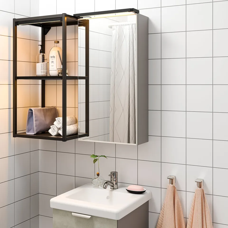 Modern bathroom with led-lit mirror cabinet above sink, featuring open shelves with toiletries.