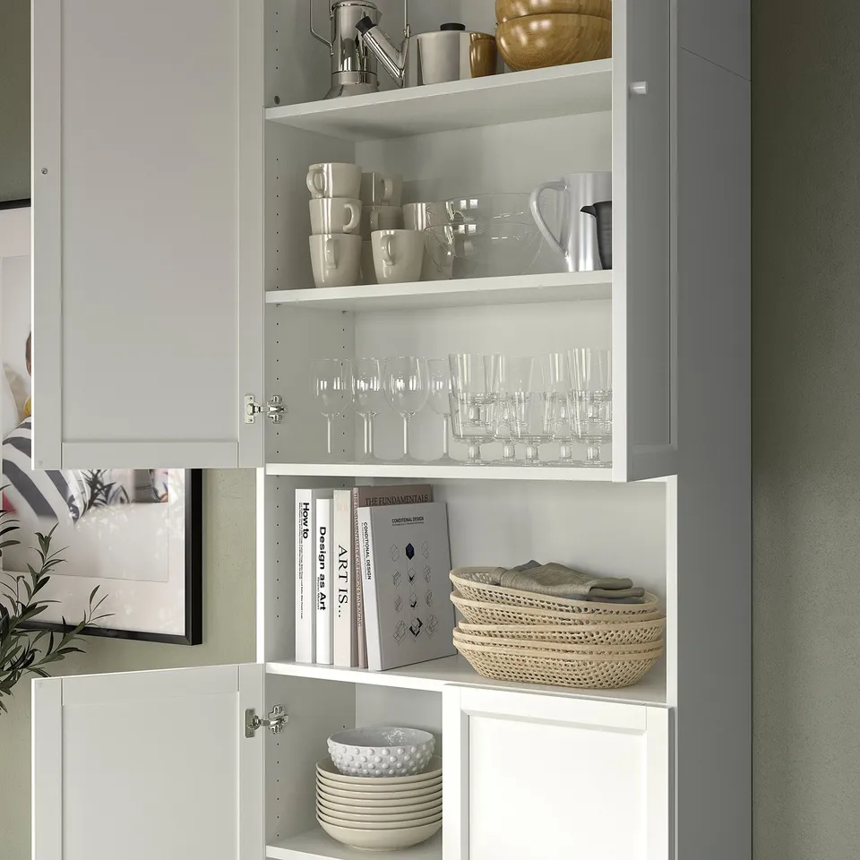 White BILLY bookcase with glassware, books, bowls & basket. Modern, organised kitchen storage.