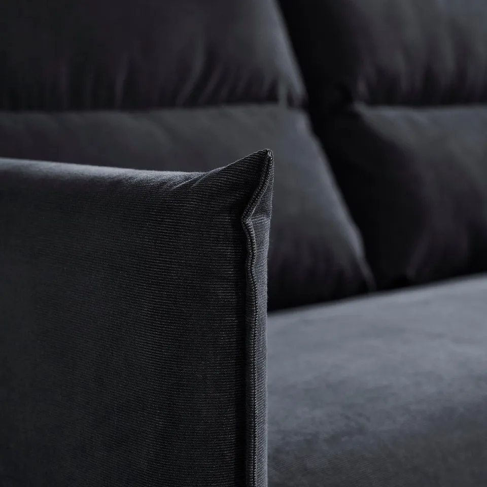 Close-up of a sleek, dark, velvet sectional sofas cushion, showcasing its plush texture and clean stitching.