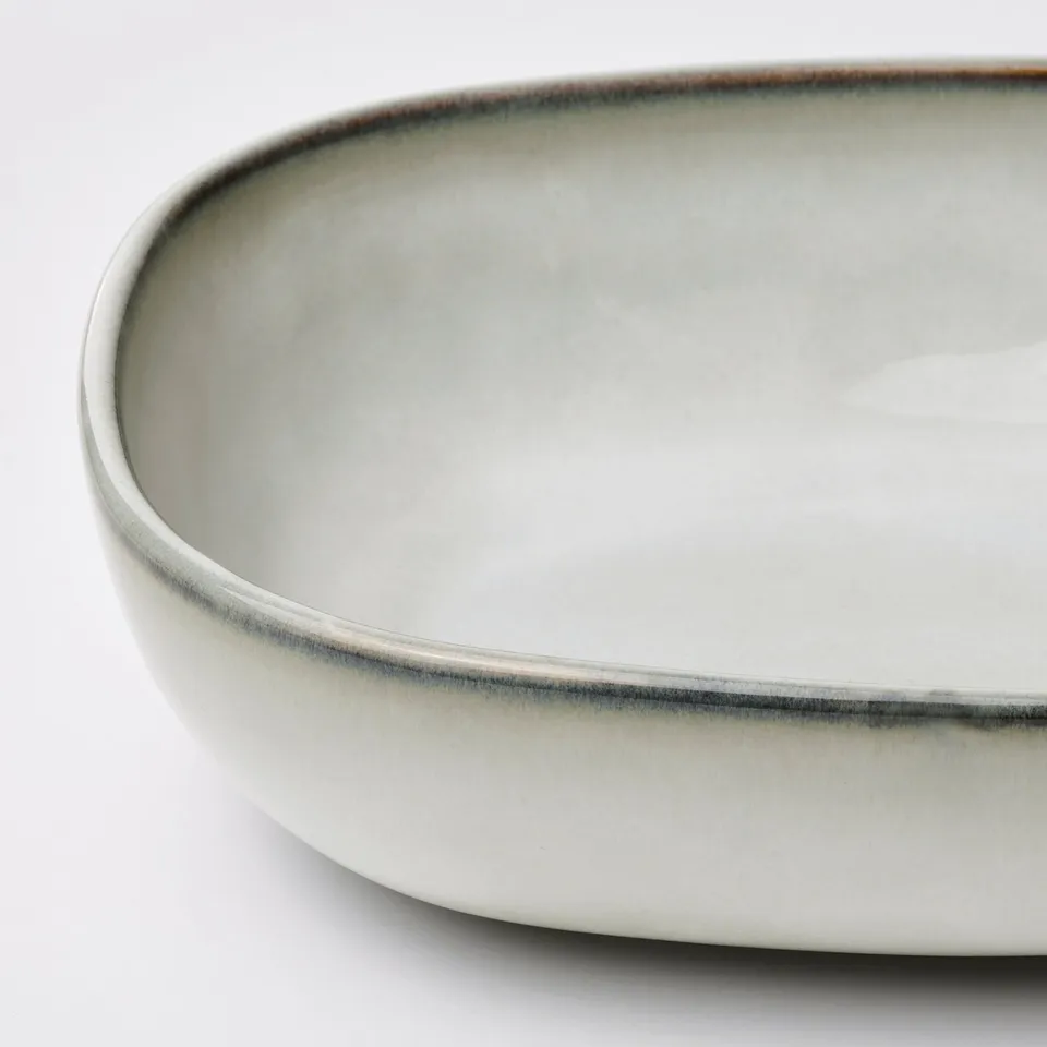Elegant oval dish with textured, glazed surface. Smooth, sturdy edges, ideal for serving.