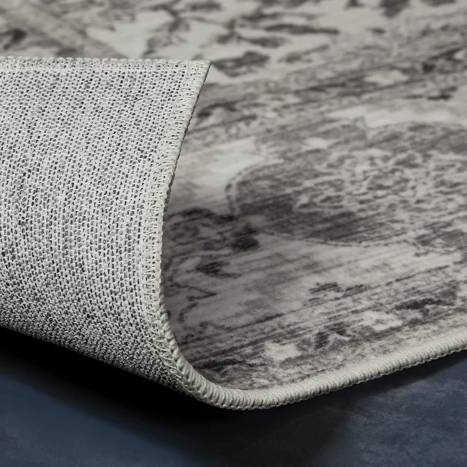 Close-up of recycled fabric texture, dark grey LOKALTÅG material with visible weave and pattern.