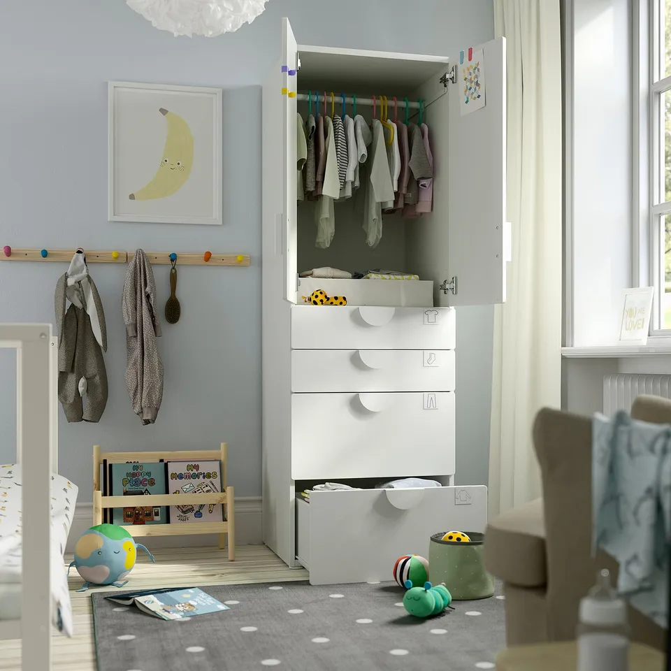 Childs room with white SMÅSTAD wardrobe, hangers, clothes, toys, books.