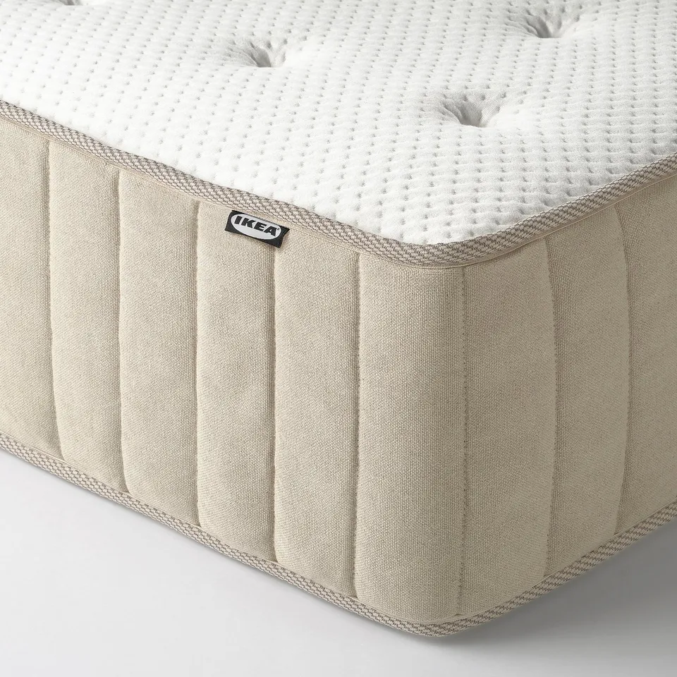 Close-up of a firm ikea mattress showcasing its texture and quality. Fine details of stitching, natural fabric, and brand tag visible.