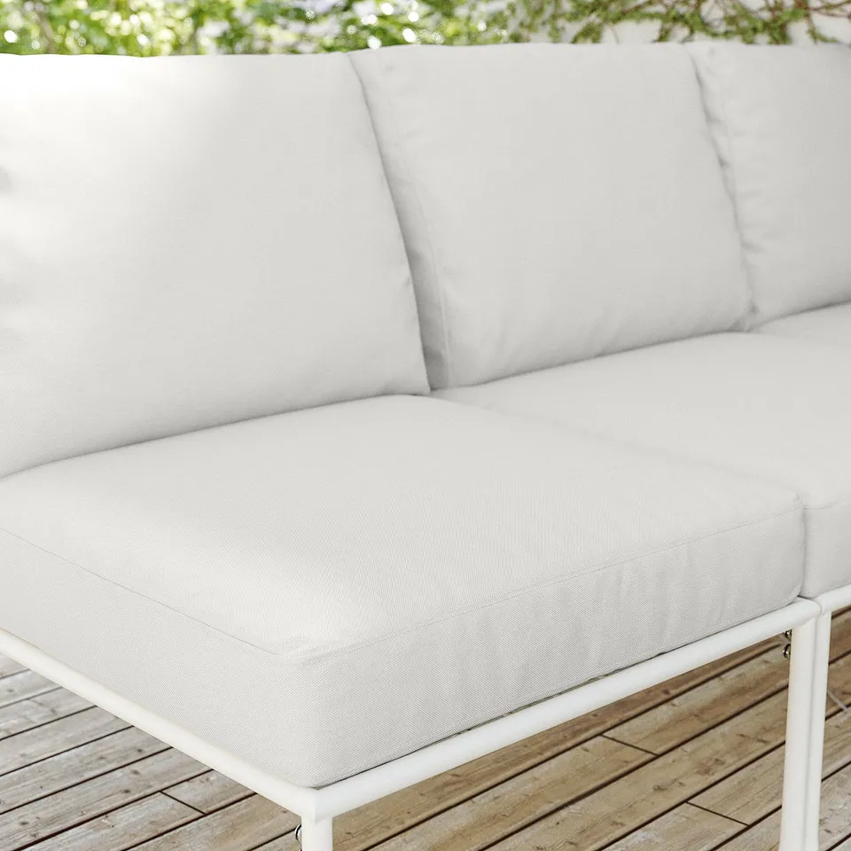 Image depicts a modern, white SEGERÖN outdoor couch on a wooden deck. The couch sleek lines and plush cushions.